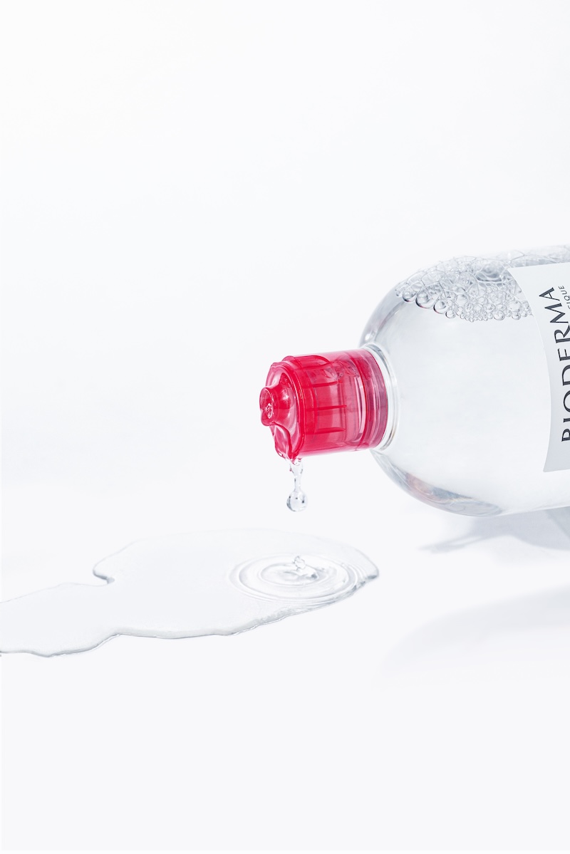 botella de agua micelar vertiendo gotas