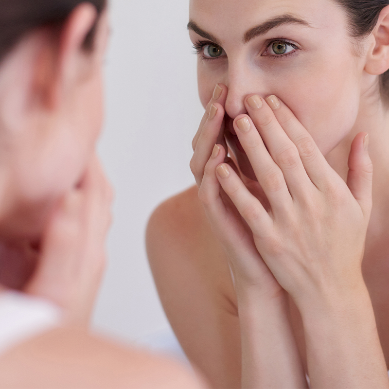 mujer que se toca la cara